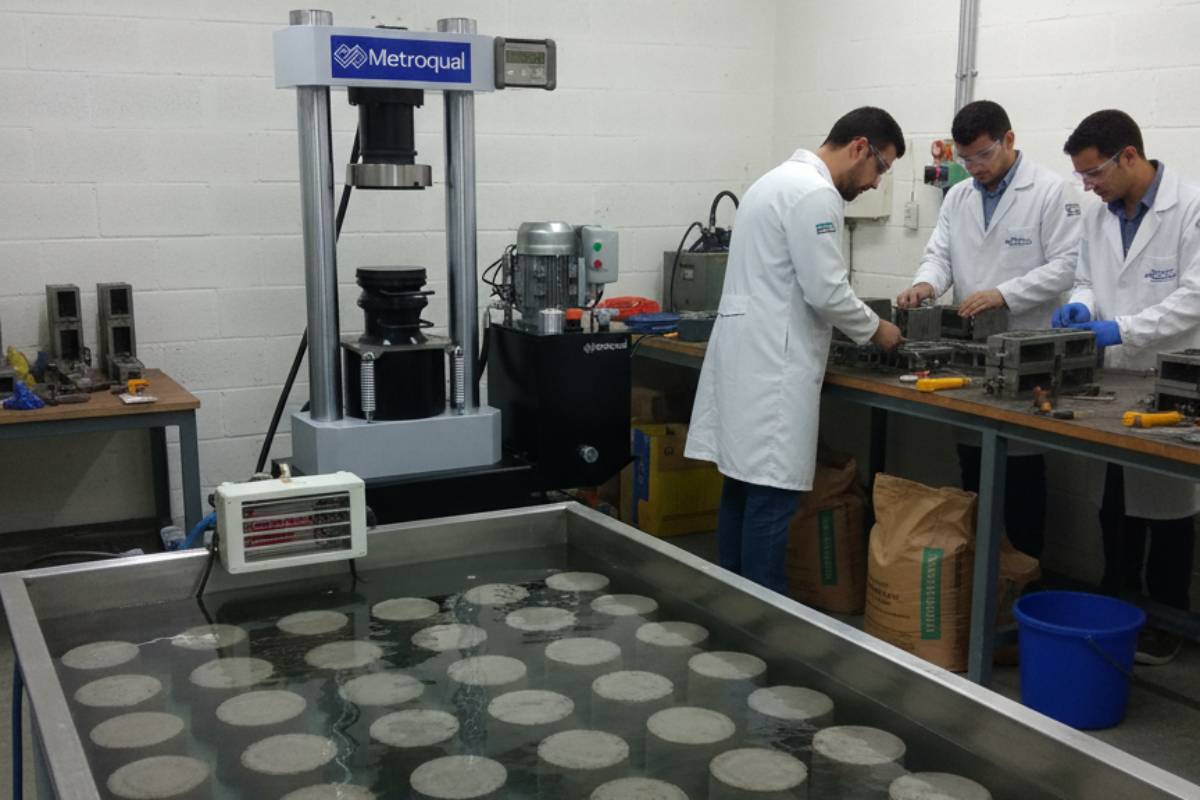 Operador preparando corpo de prova de cimento conforme NBR 7215 em laboratório